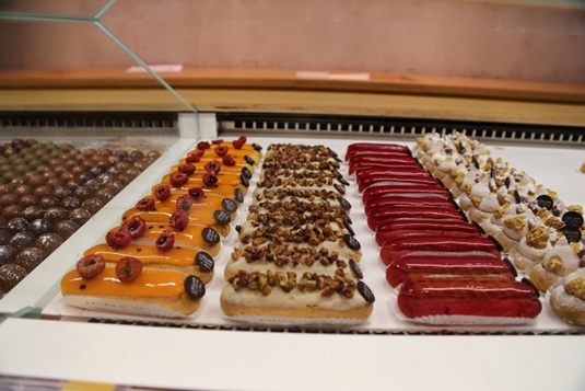 The eclairs have fresh toppings like raspberries and chopped nuts.